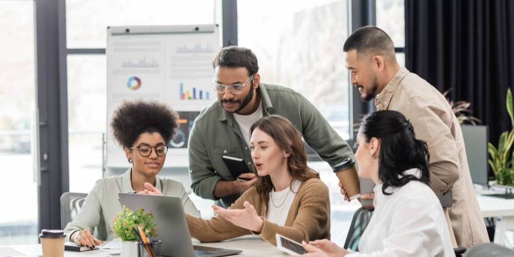 asccounting employess looking at laptop