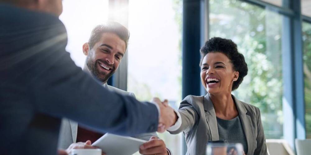 Man shaking womans hand in accounting office